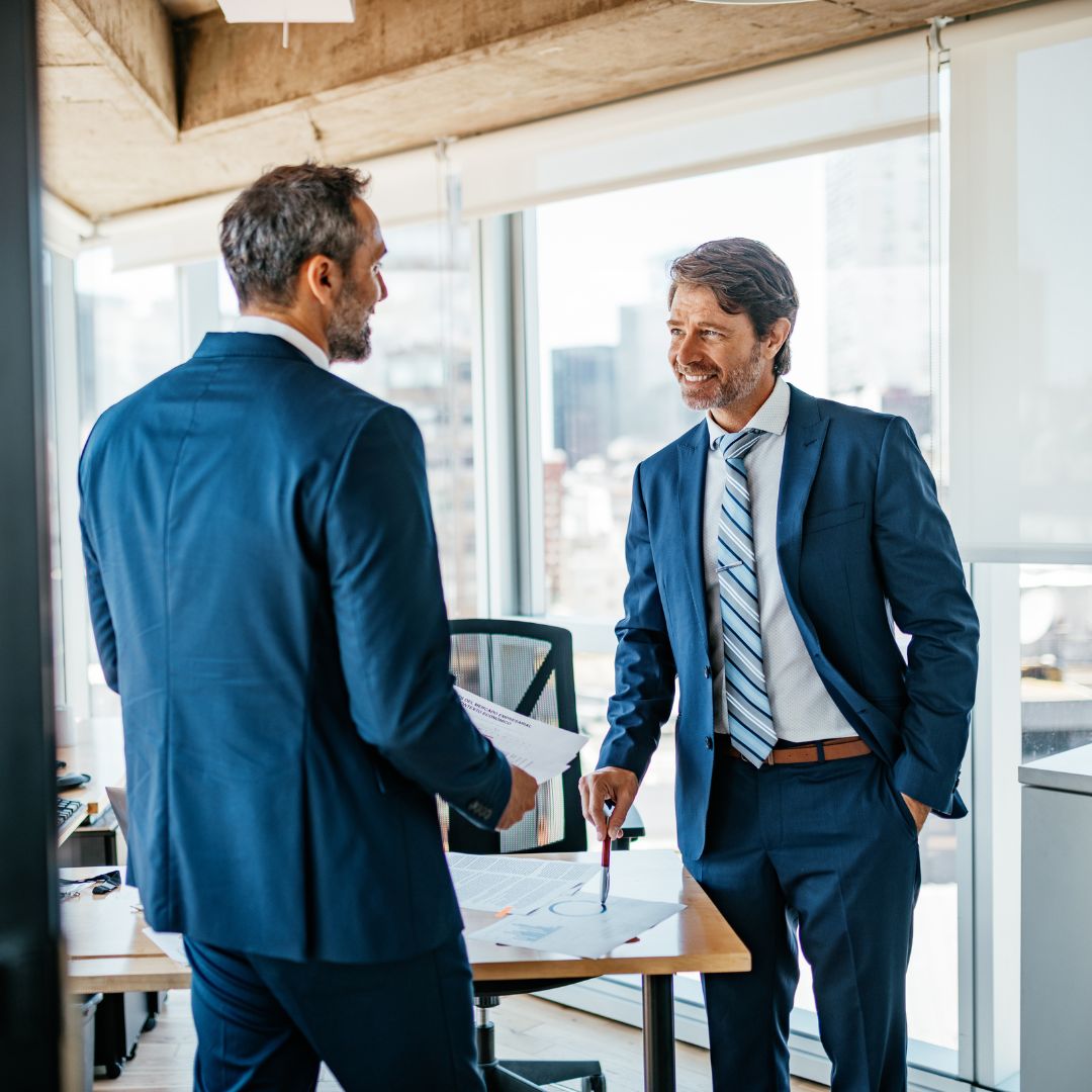 men in suits standing in an office