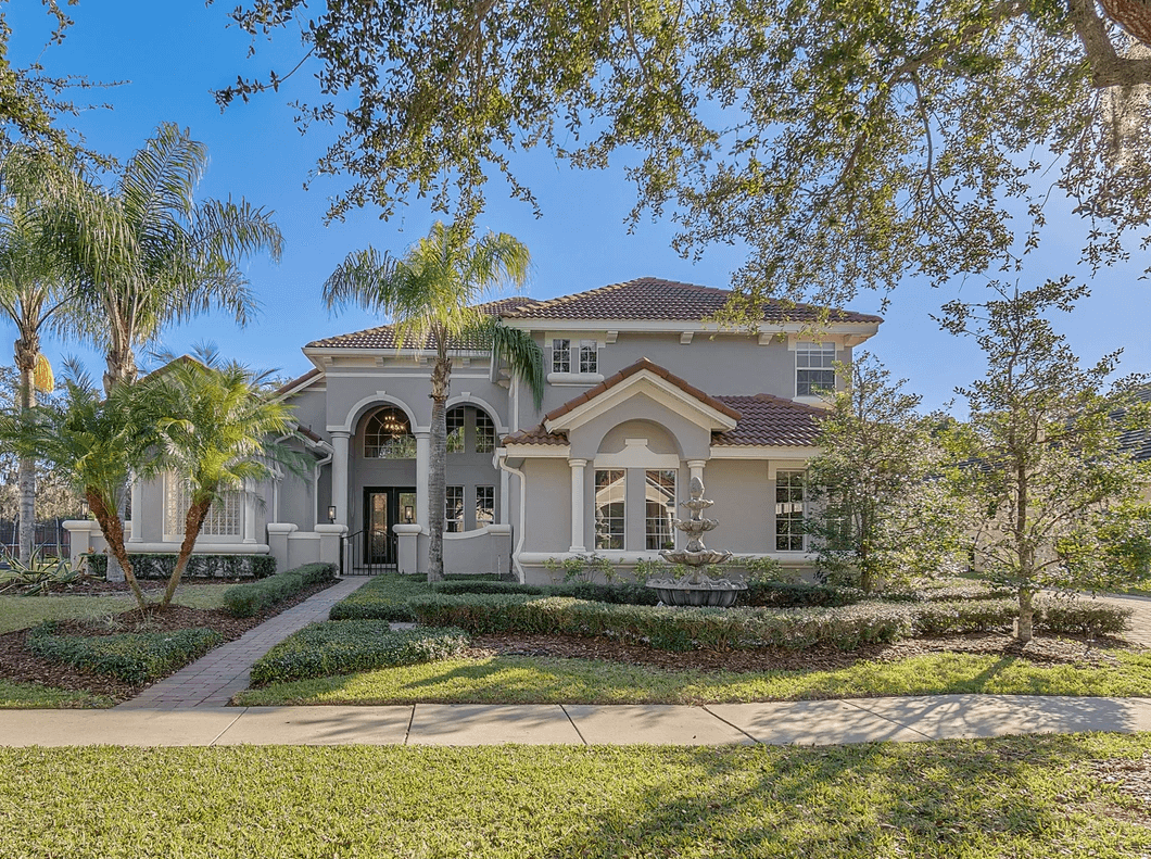 house with clay tile roof and mature landscaping