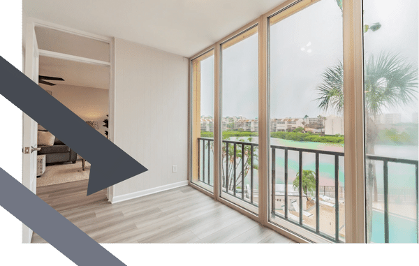 wall of windows with views of pool and palm trees