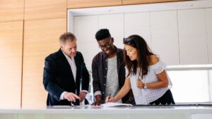 real estate agent stands in kitchen with clients