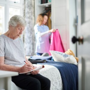 lady helps a senior with house chores