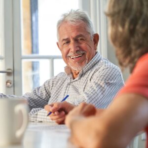 man sits in front of window smiling
