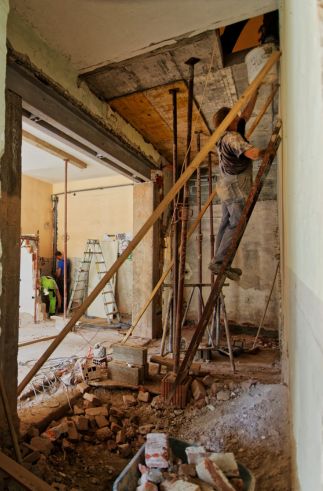 person works in a construction site with exposed brick