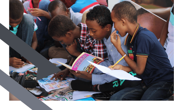 kids sit in a row reading school books