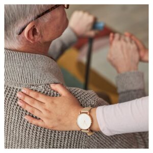 woman places hand with watch on wrist on older man's shoulder
