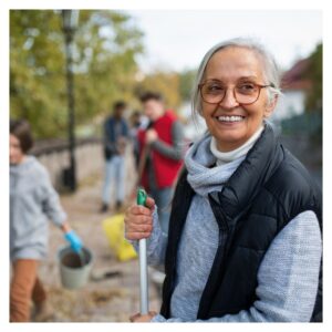 older woman in a sweater smiles while outside