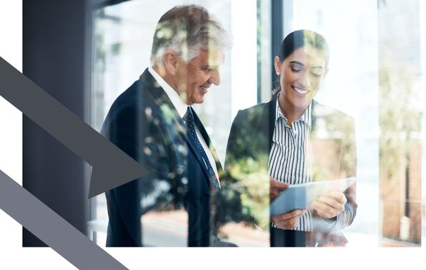 man stands beside a woman in office with glass wall