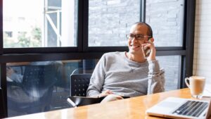 man sitting at desk talking on phone