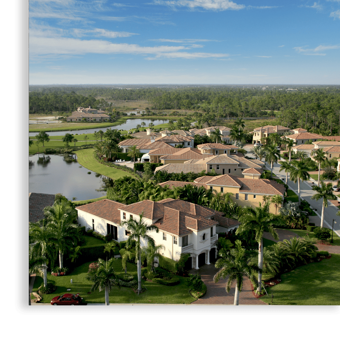 areal view of large houses with water and palm trees